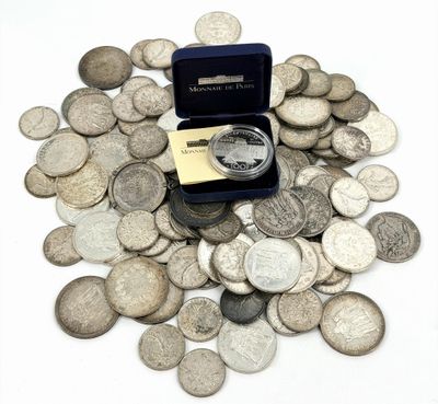une petite boîte surmontée d'une bague, posée au sommet d'une pile de pièces de monnaie