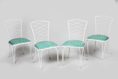quatre chaises en métal blanc, ornées de coussins verts, sur fond gris