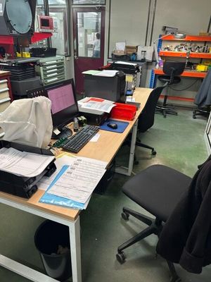 un bureau avec un ordinateur et une chaise dans une pièce