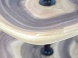 a three tiered cake stand with a marble design on it