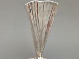 un vase en argent posé sur une table