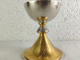 a silver and gold chalicet on a white table