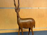 a wooden sculpture of a antelope in a room