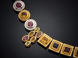 a close up of a necklace with various colored stones on a black surface