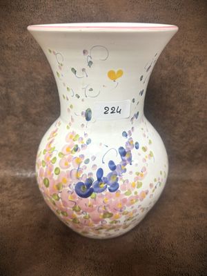 un vase blanc orné de fleurs peintes sur un fond marron
