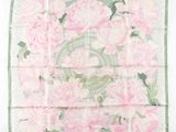 un foulard carré à motifs floraux roses et verts sur fond blanc