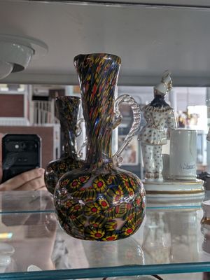 many different vases on the glass shelves in the store