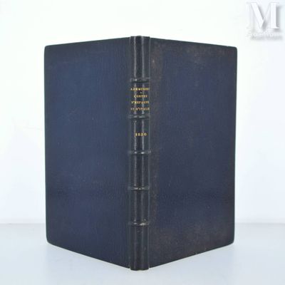 un vieux livre posé sur une table à côté d'un mur blanc