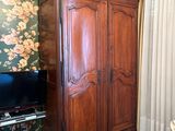une grande armoire en bois dans un coin du salon