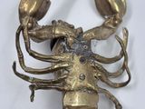 gold plated lobster broochle on a white background