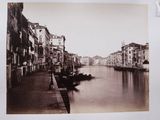 a black and white photo of a canal with boats on it