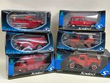 four red toy cars are in boxes on a white surface