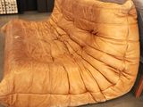 a brown leather chair sitting on the floor in a living room