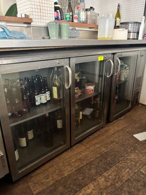 des bouteilles de vin sont posées dans une vitrine en verre dans une cuisine