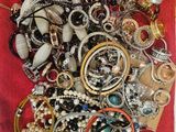un sac rouge rempli de nombreux bijoux posé sur une table