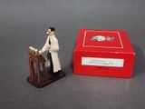 a small figurine of a man giving a speech in front of a red box