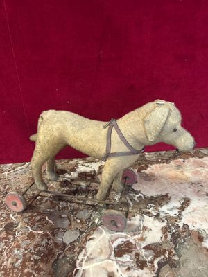 statue of a dog on a rock with a harness around it ' s neck