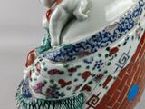 a figurine of a woman with a cat on her lap
