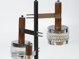 two lights that are hanging from a metal pole