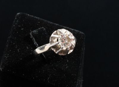 a close up of a diamond ring on a black velvet surface
