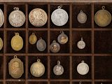 many different types of silver and gold coins in a display case
