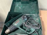 a green box with a drill and a cord in it