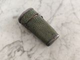 un petit briquet vert posé sur une surface en marbre