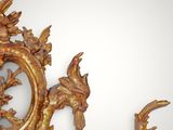 a gold mirror with a bird and flowers on it