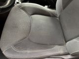 a cat sitting in the driver ' s seat of a car