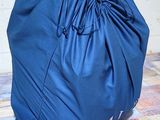 a blue bag sitting on the floor next to a brick wall