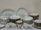 de nombreuses assiettes et tasses posées sur une table, avec une statue en arrière-plan
