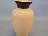 a small vase with a brown lid on a table