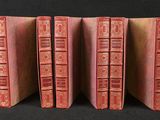 four red books are lined up in a row on a black background
