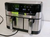 an air fryer sitting on a counter with a cord plugged into it