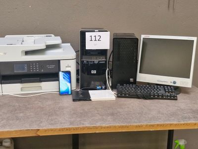 a desk with a computer, printer, and a cell phone on it
