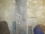 a chair and a barrel in a room with cement walls