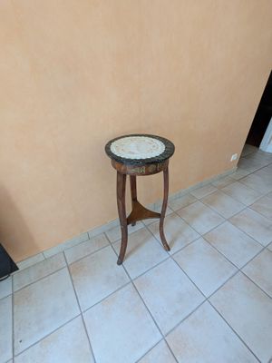 une petite table au plateau en marbre, dans un coin de la pièce