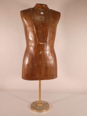 une image représentant un mannequin en bois posé sur un socle métallique