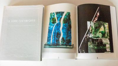 two books are open on a white table with a white table cloth