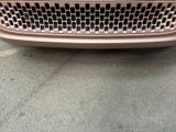the front bumper of a car with a grille made out of squares
