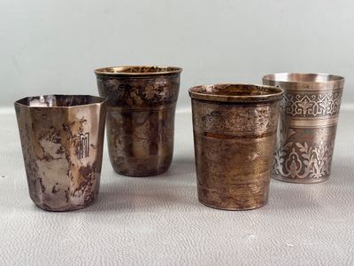 four silver cups sitting on top of a table next to each other