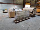 un gros tas de bois dans un entrepôt rempli de palettes et de cartons