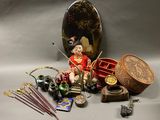 une petite poupée posée sur une table, à côté d'autres objets