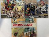 trois livres posés sur une surface blanche, avec une tour horloge en arrière-plan