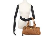 a mannequin mannequin holding a brown handbag on a white mannequin mannequin mannequin mannequin mannequin manne
