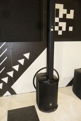 a black stove sitting next to two speakers in a room