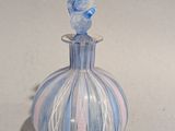 un vase bleu et blanc surmonté d'un oiseau