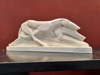 a white sculpture of a dog and a cat on a table