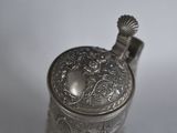 a silver vase that has a handle on it