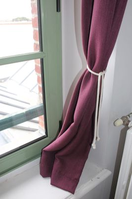 a window with a curtain on it and a radiator in front of it